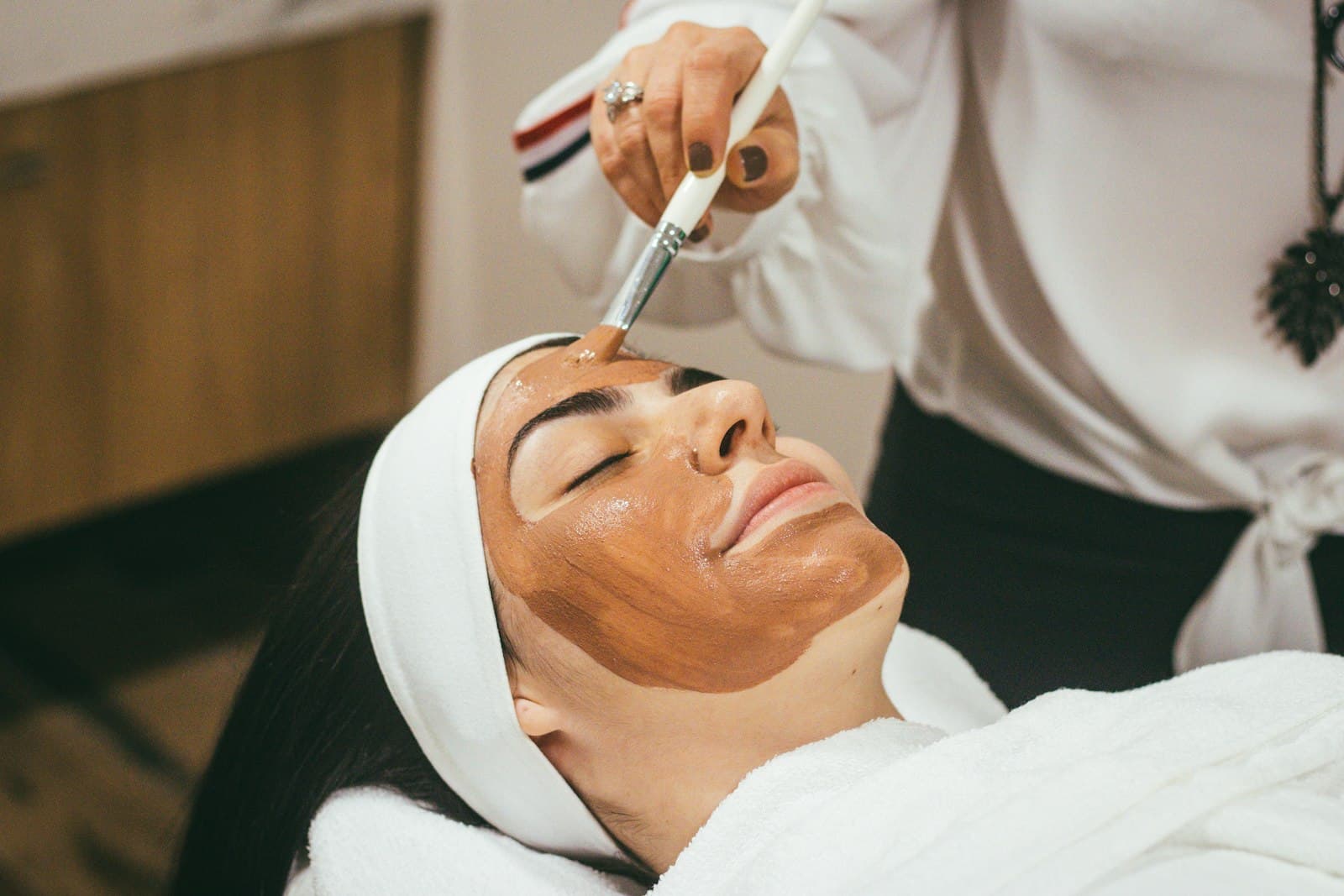 A treatment mask being applied during a facial