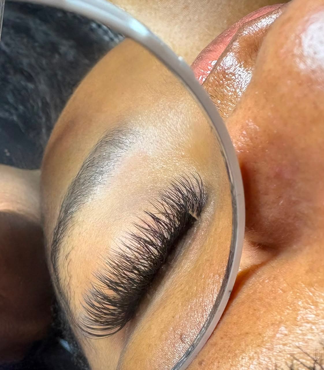 A lash and brow set shown in a round mirror