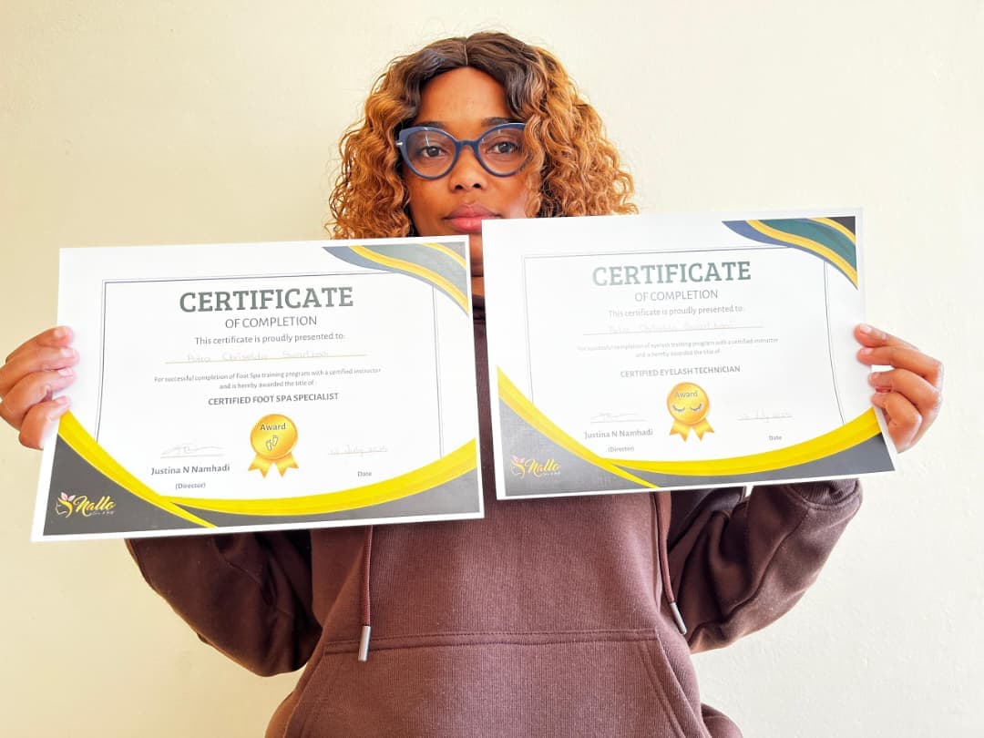 A Nallo academy graduate holding her completion certificates